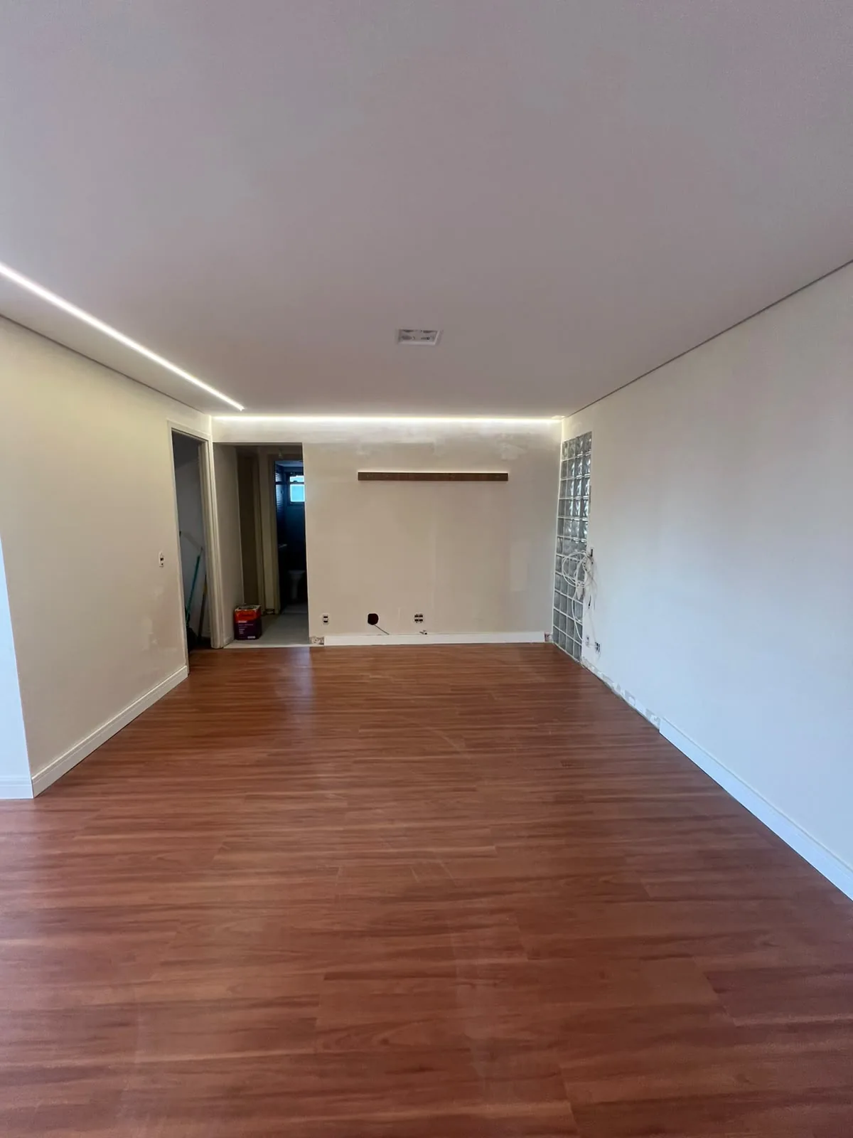 Depois: sala reformada com piso de madeira e paredes pintadas em São Paulo