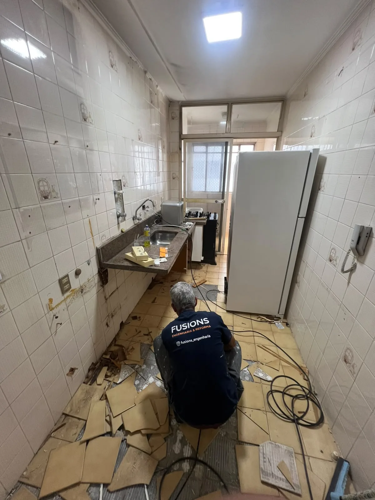 Antes: cozinha antiga com revestimento sendo removido em reforma em São Paulo